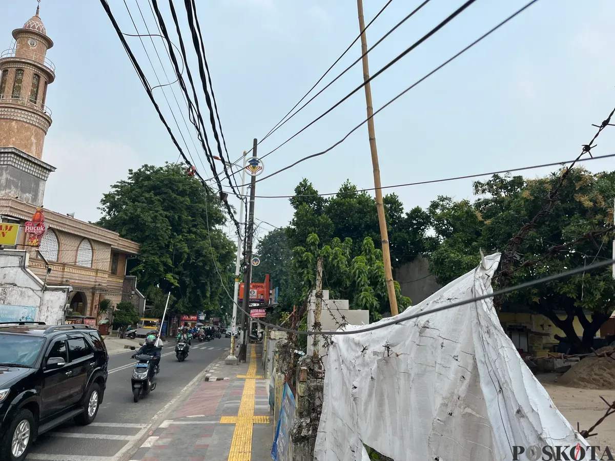 Salah satu keberadaan kabel semrawut yang menjuntai di trotoar Jalan Meruya Selatan, Kembangan, Jakarta Barat, Selasa, 2 Desember 2025. (Sumber: Poskota/Pandi Ramedhan)