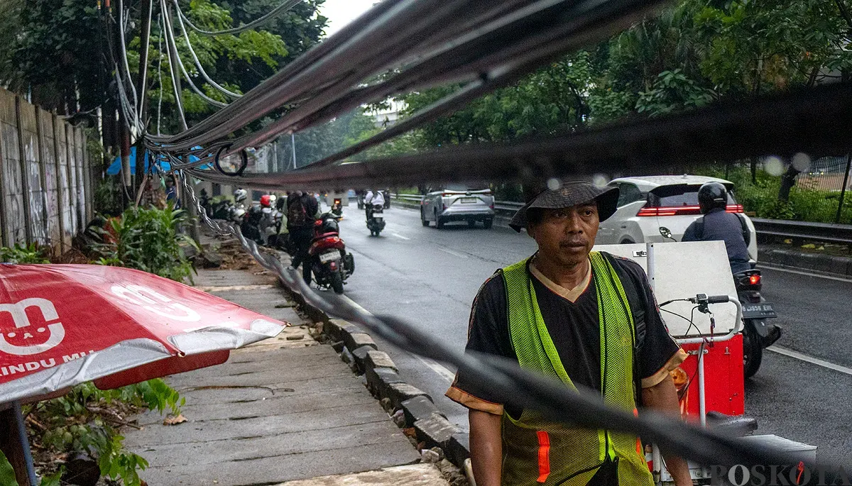 Kabel-kabel listrik menjuntai di sepanjang Jalan Tahi Bonar (TB) Simatupang arah Pasar Rebo, Jakarta Selatan pada Selasa, 2 Desember 2025. (Sumber: POSKOTA | Foto: Dhiya Ahmad Fauzan/M2)
