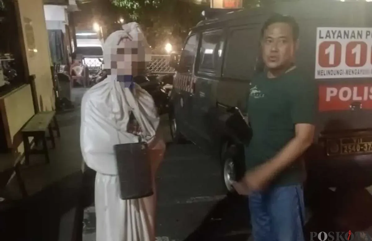 Polisi mengamankan remaja pengamen berkostum menyerupai pocong yang telah membuat resah masyarakat. (Sumber: Poskota/Angga Pahlevi)