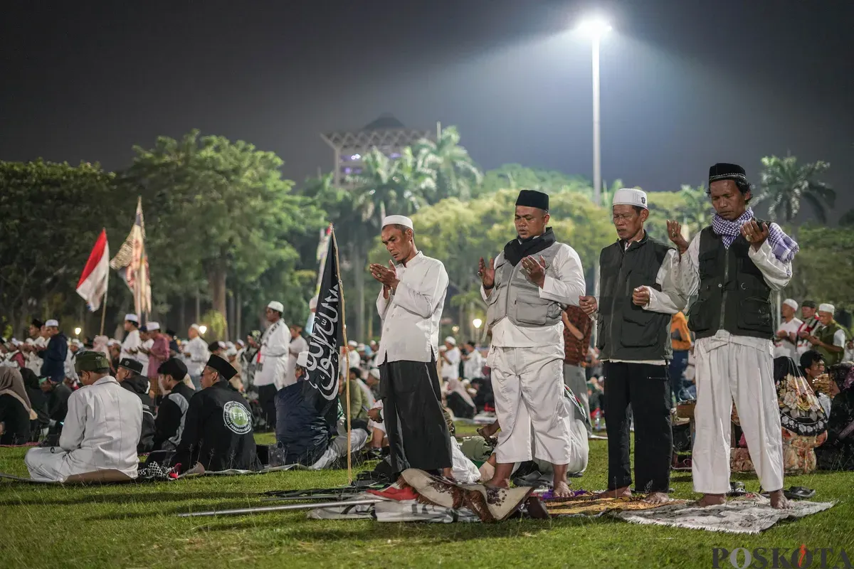 Peserta aksi reuni 212 bersholawat dan melaksanakan sholat isya berjamaah di Silang Monas, Selasa, 2 Desember 2025. (Sumber: Poskota/Bilal Nugraha Ginanjar)