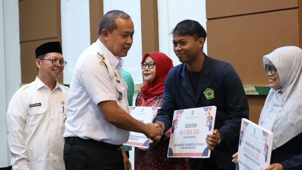 Wali Kota Bekasi, Tri Adhianto menyerahkan bantuan beasiswa kepada mahasiswa se- Kota Bekasi. (Sumber: Dok. Pemkot Bekasi)