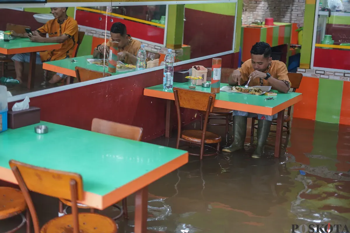 Sejumlah warga terlihat beraktifitas ditengah genangan air akibat banjir rob yang melanda kawasan Muara Angke, Jakarta Utara, Kamis, 4 Desember 2025. (Sumber: Poskota/Bilal Nugraha Ginanjar)