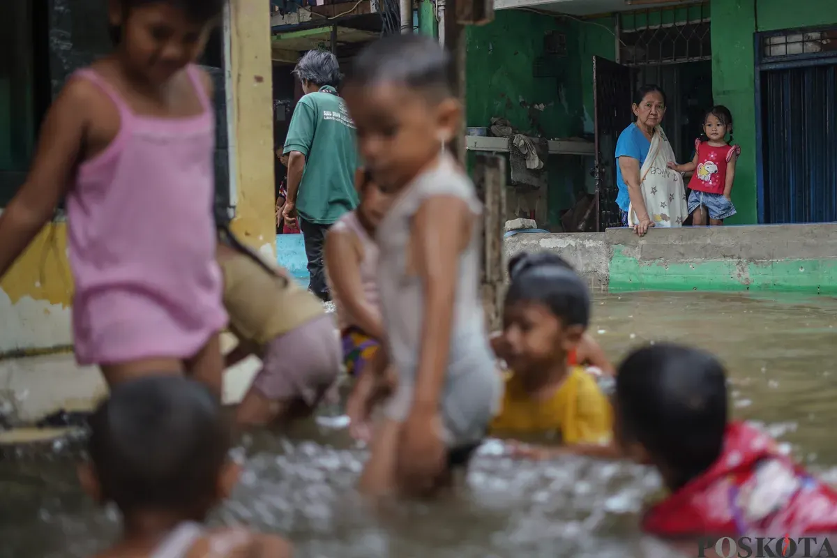 Sejumlah warga terlihat beraktifitas ditengah genangan air akibat banjir rob yang melanda kawasan Muara Angke, Jakarta Utara, Kamis, 4 Desember 2025. (Sumber: Poskota/Bilal Nugraha Ginanjar)