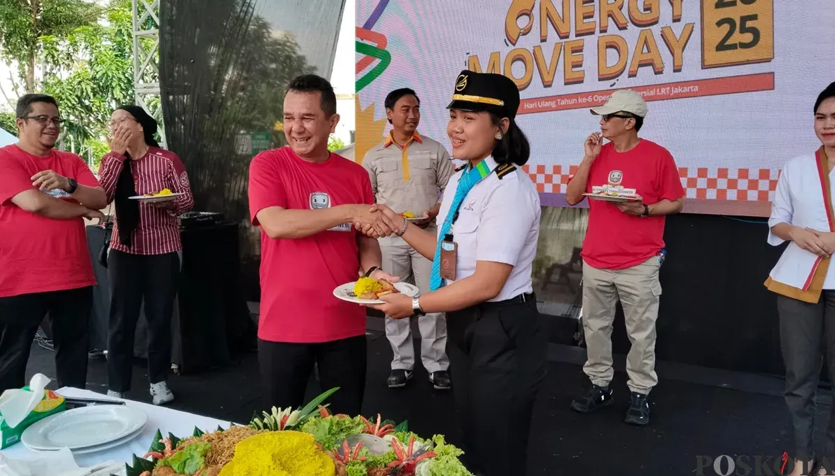 Direktur Utama LRT Jakarta, Roberto Akyuwen (kiri), memberikan potongan tumpeng kepada masinis. (Sumber: POSKOTA | Foto: Heri Effendi)