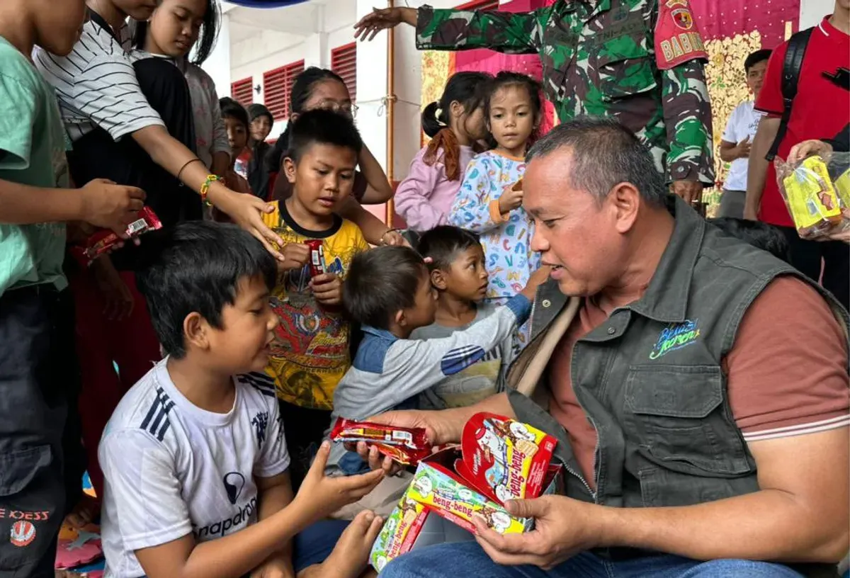 Wali Kota Bekasi, Tri Adhianto, membagikan makanan ringan kepada anak-anak terdampak banjir di Posko Pengungsian SDN 02 Cupak Tangah, Kecamatan Pauh, Kota Padang, pada Sabtu, 6 Desember 2025. (Sumber: Dok Humas Pemkot Bekasi)
