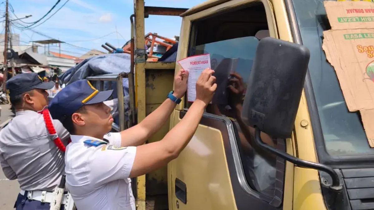 Petugas Dishub Kota Tangsel menempelkan stiker teguran pada kendaraan terparkir sembarangan di area Pasar Ciputat. (Sumber: Dok. Istimewa)
