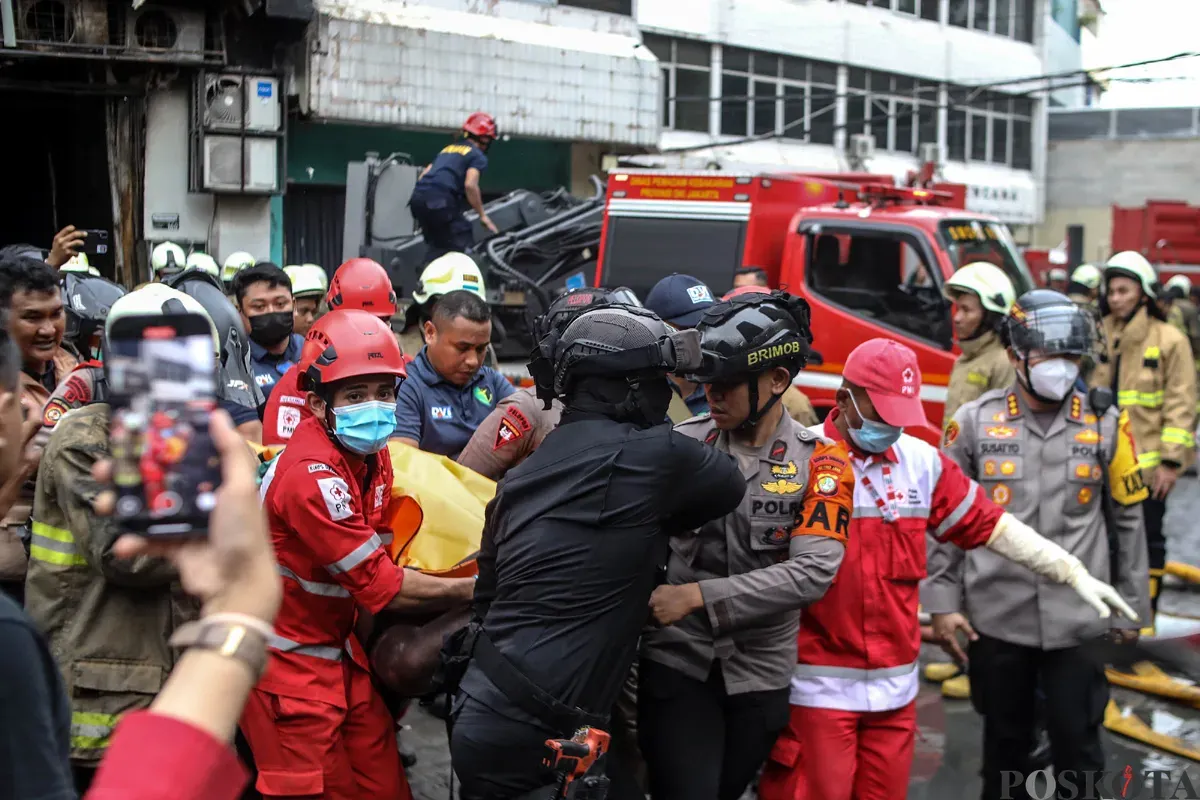 Petugas mengevakuasi jenazah dari dalam Gedung Terra Drone yang terbakar di Kemayoran, Jakarta Pusat, Selasa 9 Desember 2025. (Sumber: POSKOTA | Foto: Bilal Nugraha Ginanjar)