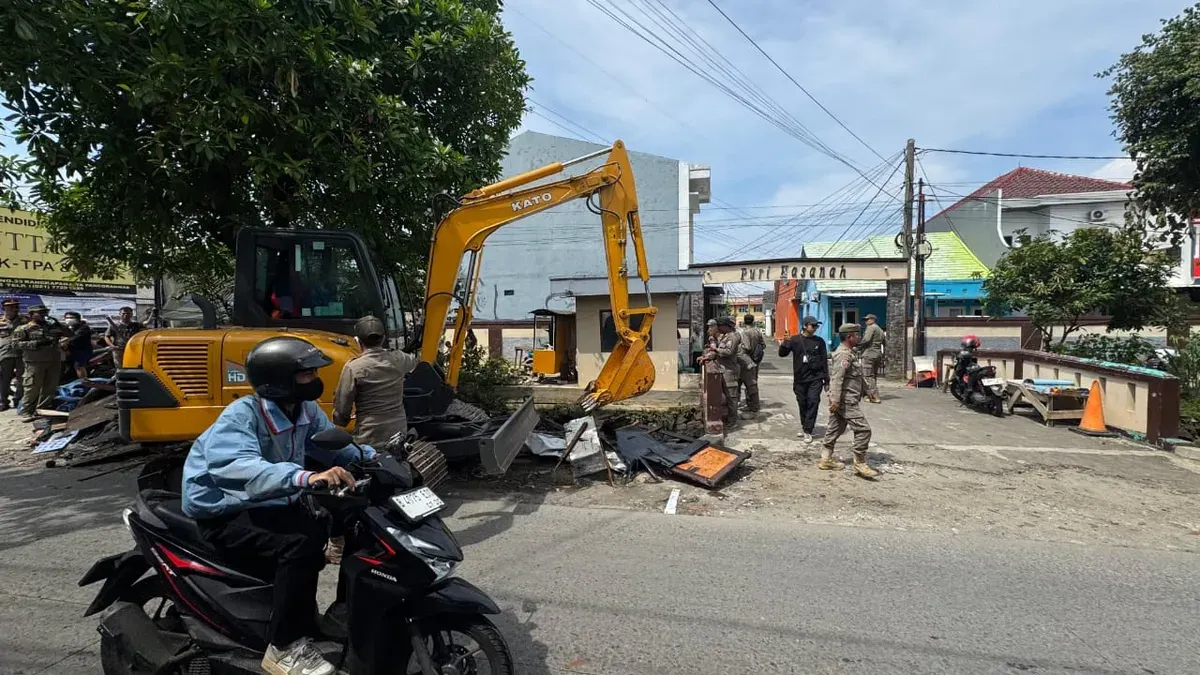 Petugas Satpol PP Depok membongkar bangunan liar di bantaran Kali Licin, Pancoran Mas. Dalam operasi ini, petugas juga menyita 115 botol minuman keras yang disembunyikan di belakang sebuah rumah. (Sumber: Istimewa)
