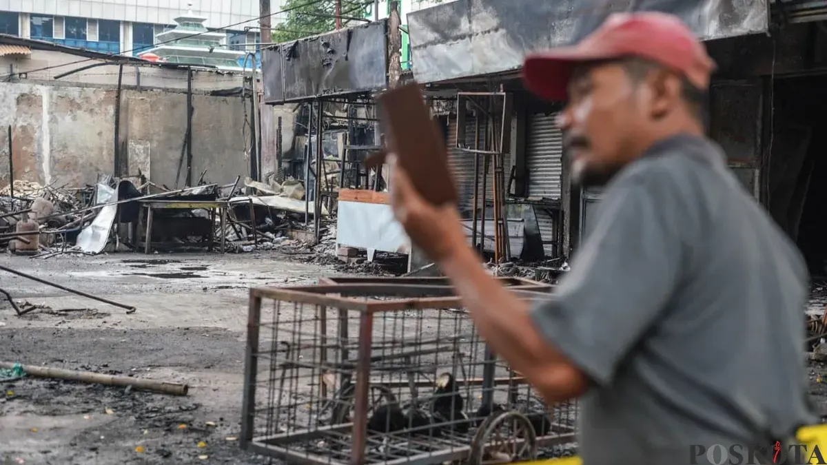 Seorang warga mengabadikan lokasi kerusuhan matel di kawasan Taman Makam Pahlawan Kalibata, Pancoran, Jakarta Selatan, Jumat, 12 Desember 2025. (Sumber: Poskota/Bilal Nugraha Ginanjar)