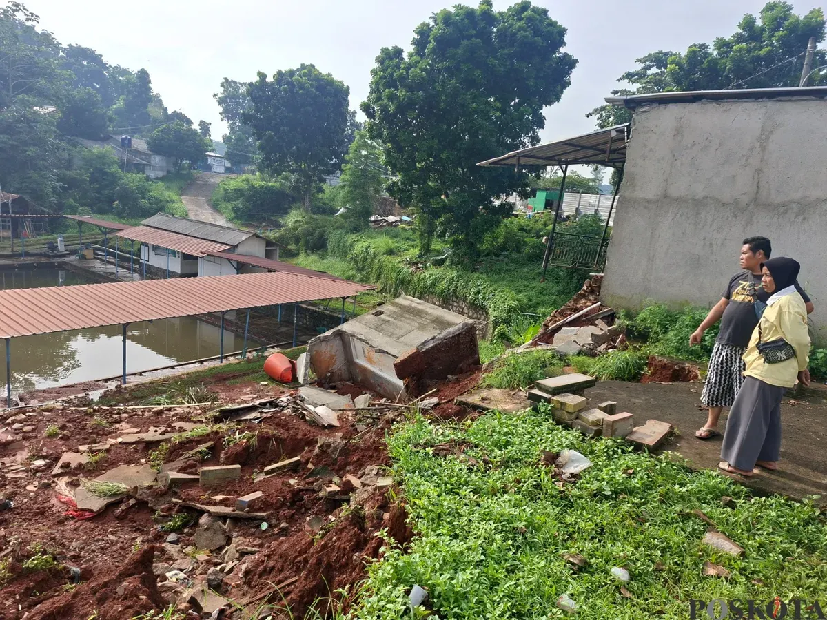 Warga melihat kondisi tebing pembatas Perumahan SIK di Kelurahan Kedaung, Sawangan, Depok, yang longsor akibat luapan air Setu Tujuh Muara setelah hujan deras, Kamis, 11 Desember 2025. (Sumber: Poskota/Angga Pahlevi)