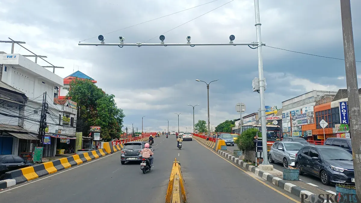 Pengendara melintas di bawah Kamera ETLE di Flyover Cibinong, Minggu 14 Desember 2025. (Sumber: Poskota/Giffar Rivana)