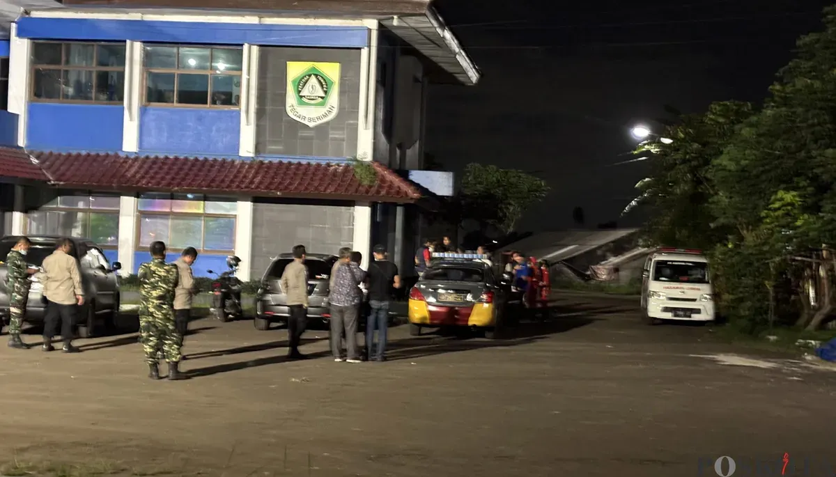 Sejumlah petugas polisi dan TNI berjaga pascapenemuan sesosok mayat pria di Gedung KNPI Cibinong, Minggu, 14 Desember 2025. (Sumber: POSKOTA | Foto: Giffar Rivana)