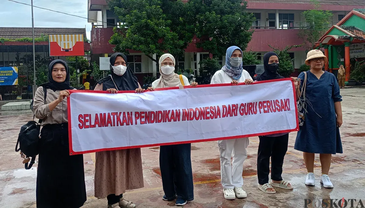 Orang tua murid di SDN Pajeleran 01 membentangkan spanduk protes tindakan diskriminatif oleh salah seorang wali kelas. (Sumber: POSKOTA | Foto: Giffar Rivana)