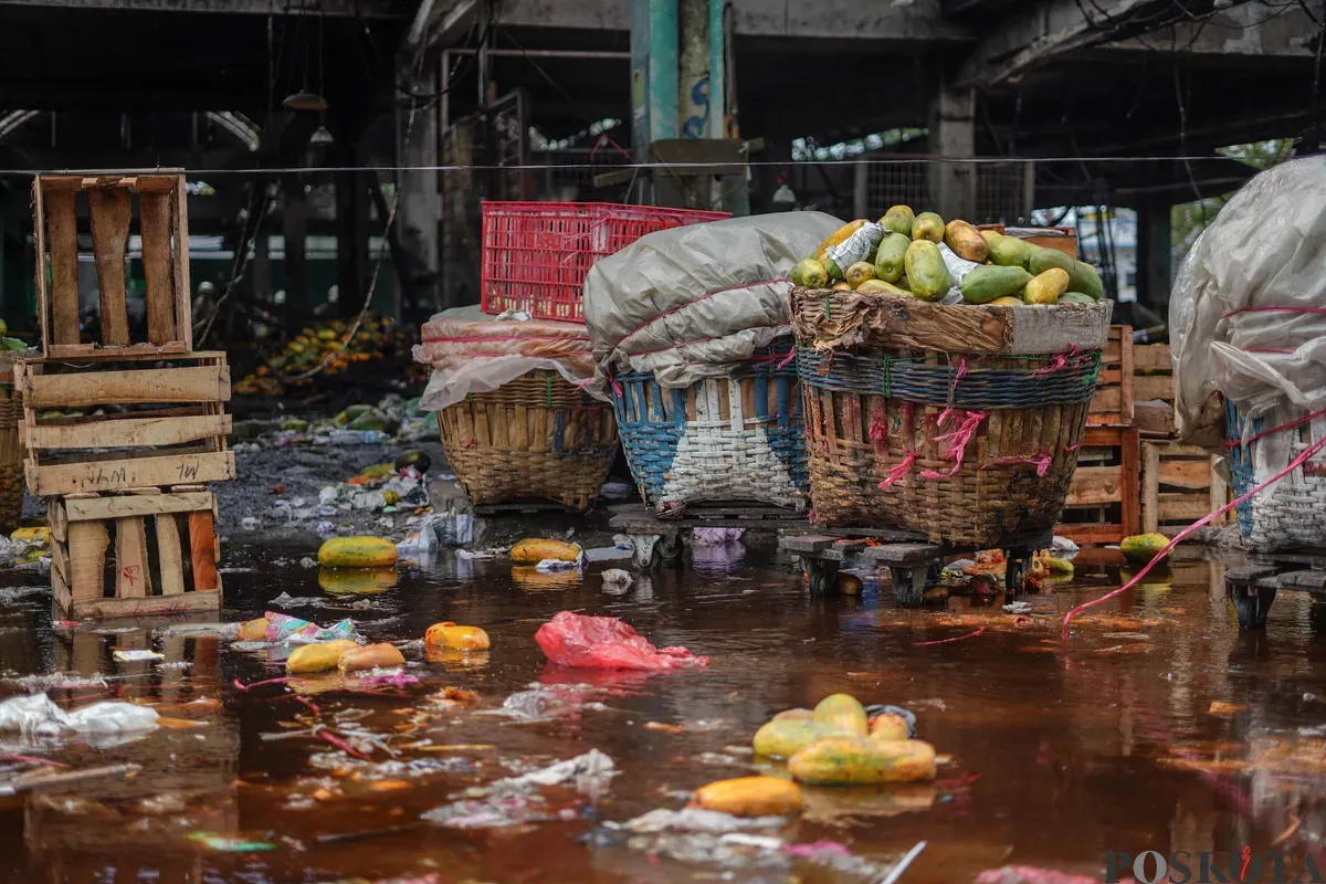 Sejumlah pedagang mengevakuasi buah yang tersisa usai kebakaran di Pasar Induk Kramat Jati, Jakarta Timur, Senin, 15 Desember 2025. (Sumber: Poskota/Bilal Nugraha Ginanjar)