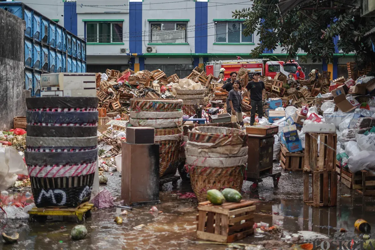 Sejumlah pedagang mengevakuasi buah yang tersisa usai kebakaran di Pasar Induk Kramat Jati, Jakarta Timur, Senin, 15 Desember 2025. (Sumber: Poskota/Bilal Nugraha Ginanjar)