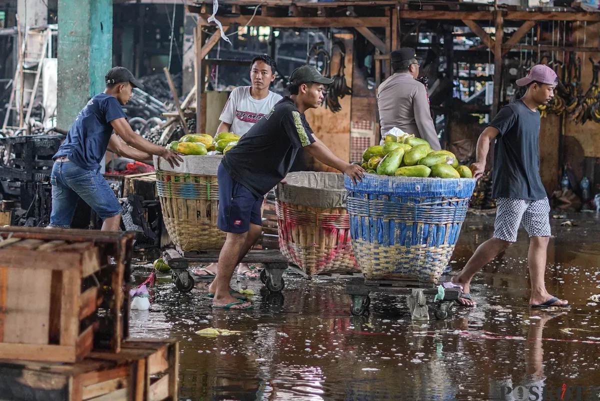 Sejumlah pedagang mengevakuasi buah yang tersisa usai kebakaran di Pasar Induk Kramat Jati, Jakarta Timur, Senin, 15 Desember 2025. (Sumber: Poskota/Bilal Nugraha Ginanjar)