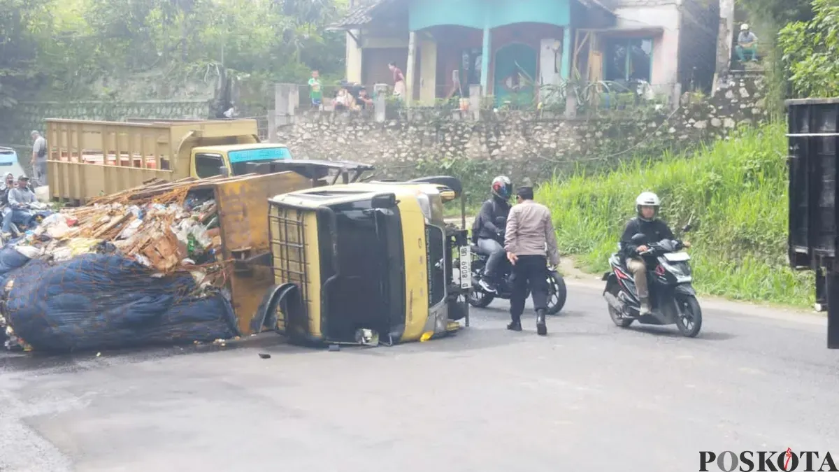 Sebuah unit truk pengangkut sampah nampak terguling di kawasan Jalan Raya Cipatat, Senin 15 Desember 2025. (Sumber: Poskota/Gatot Poedji Utomo)