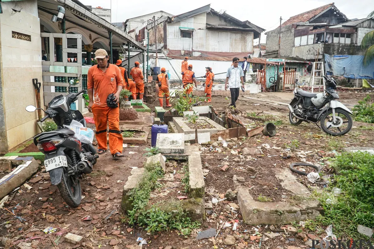 Petugas Penanganan Prasarana dan Sarana Umum (PPSU) membawa barang bongkaran rumah warga di TPU Kober Rawa Bunga, Jatinegara, Jakarta Timur, Kamis, 18 Desember 2025. (Sumber: Poskota/Bilal Nugraha Ginanjar)