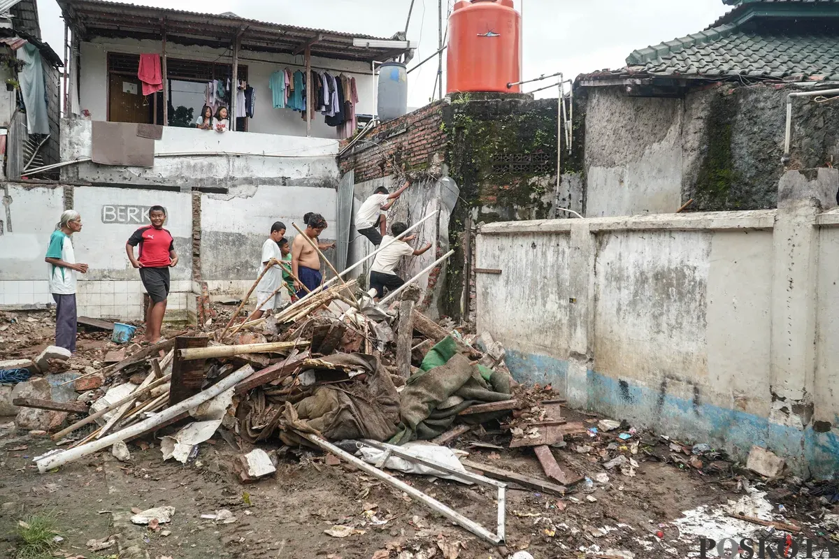 Petugas Penanganan Prasarana dan Sarana Umum (PPSU) membawa barang bongkaran rumah warga di TPU Kober Rawa Bunga, Jatinegara, Jakarta Timur, Kamis, 18 Desember 2025. (Sumber: Poskota/Bilal Nugraha Ginanjar)
