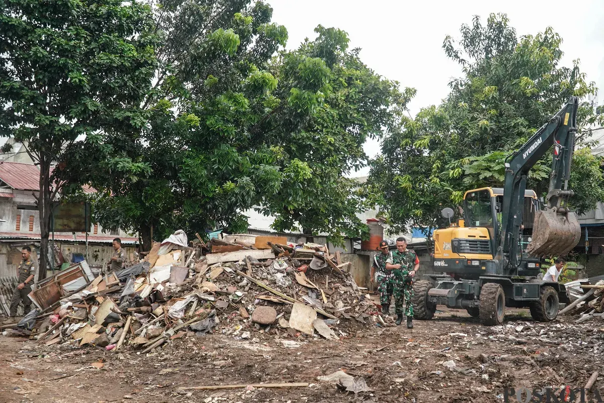 Petugas Penanganan Prasarana dan Sarana Umum (PPSU) membawa barang bongkaran rumah warga di TPU Kober Rawa Bunga, Jatinegara, Jakarta Timur, Kamis, 18 Desember 2025. (Sumber: Poskota/Bilal Nugraha Ginanjar)
