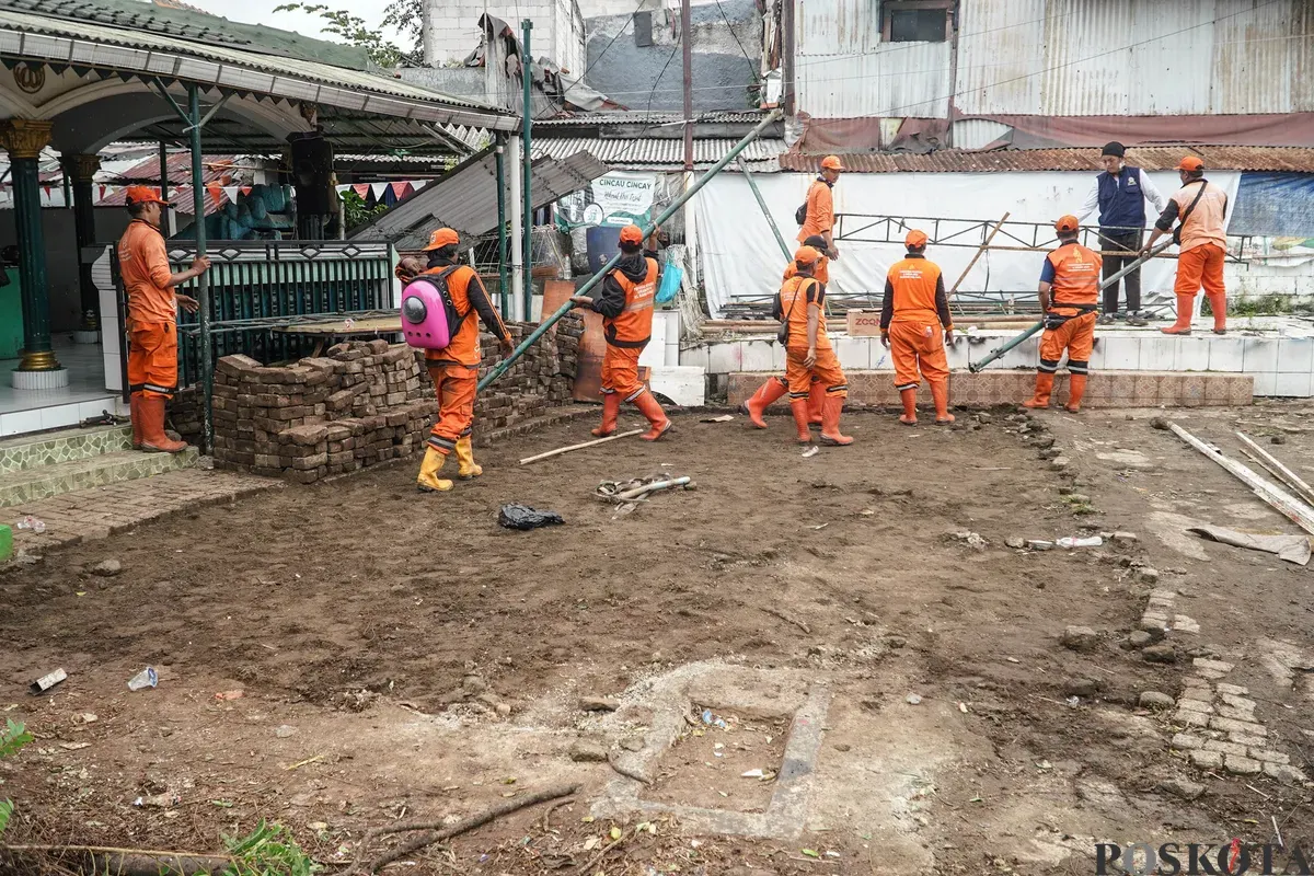 Petugas Penanganan Prasarana dan Sarana Umum (PPSU) membawa barang bongkaran rumah warga di TPU Kober Rawa Bunga, Jatinegara, Jakarta Timur, Kamis, 18 Desember 2025. (Sumber: Poskota/Bilal Nugraha Ginanjar)