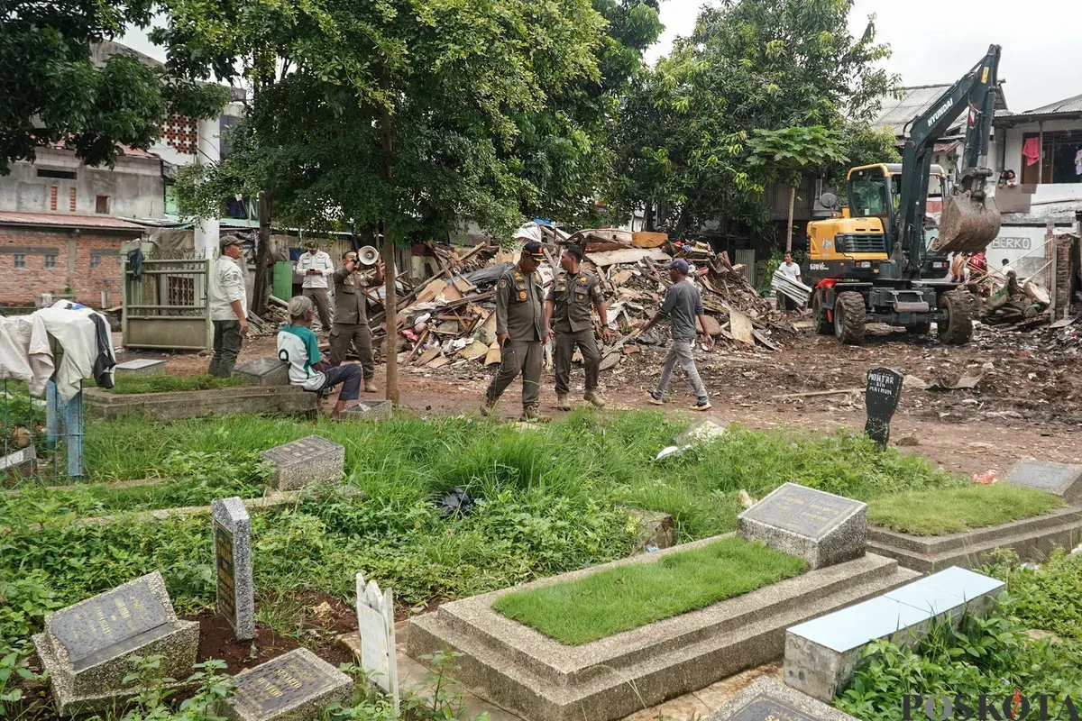 Petugas Penanganan Prasarana dan Sarana Umum (PPSU) membawa barang bongkaran rumah warga di TPU Kober Rawa Bunga, Jatinegara, Jakarta Timur, Kamis, 18 Desember 2025. (Sumber: Poskota/Bilal Nugraha Ginanjar)