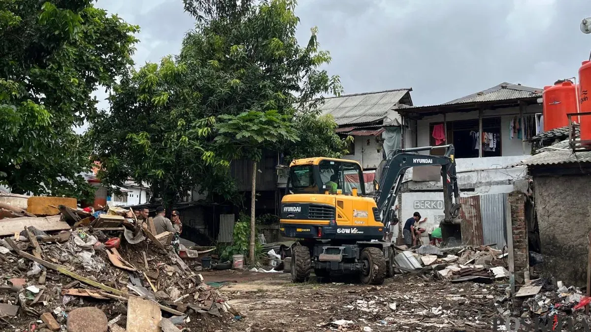 Salah satu ekskavator saat membersihkan sebuah lapak di TPU Kober Rawa Bunga, Jakarta Timur, Kamis, 18 Desember 2025. (Sumber: Poskota/M. Tegar Jihad)