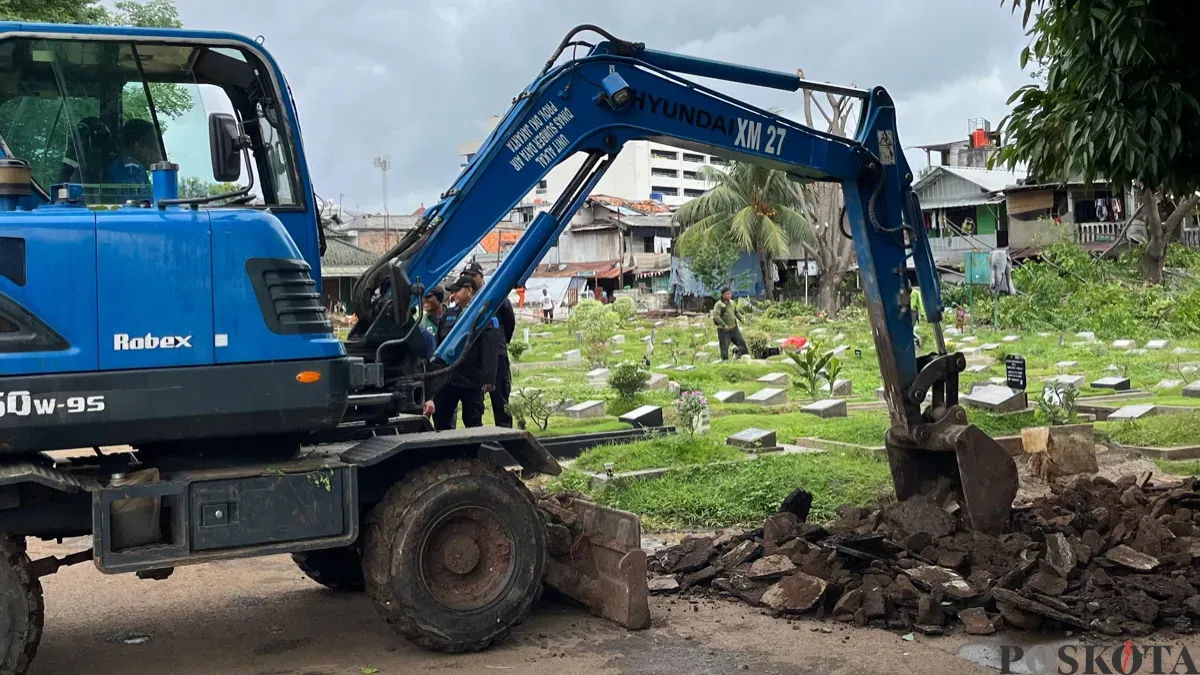 Salah satu ekskavator saat membersihkan lapak di TPU Kober Rawa Bunga, Jakarta Timur, Kamis, 18 Desember 2025. (Sumber: Poskota/M. Tegar Jihad)