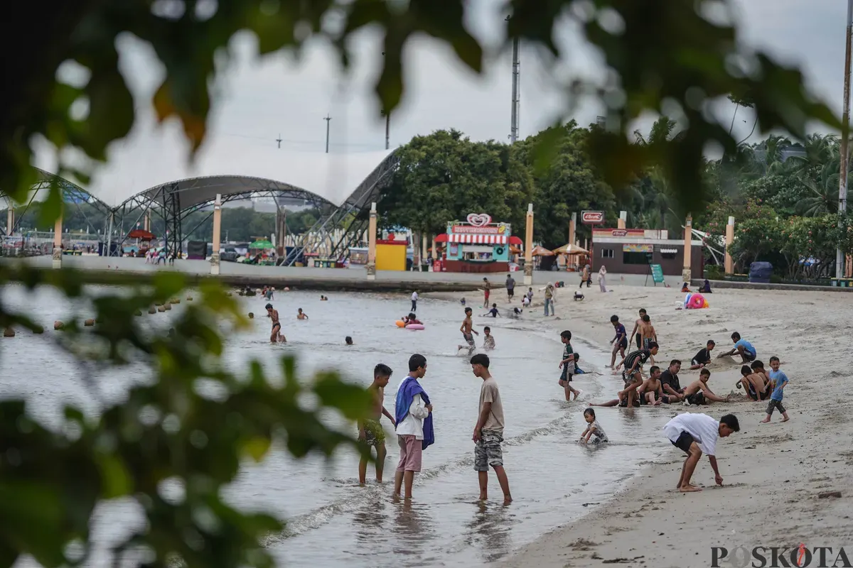 Warga bermain di pesisir Pantai Lagoon, Taman Impian Jaya Ancol, Jakarta, Jumat, 19 Desember 2025. (Sumber: Poskota/Bilal Nugraha Ginanjar)