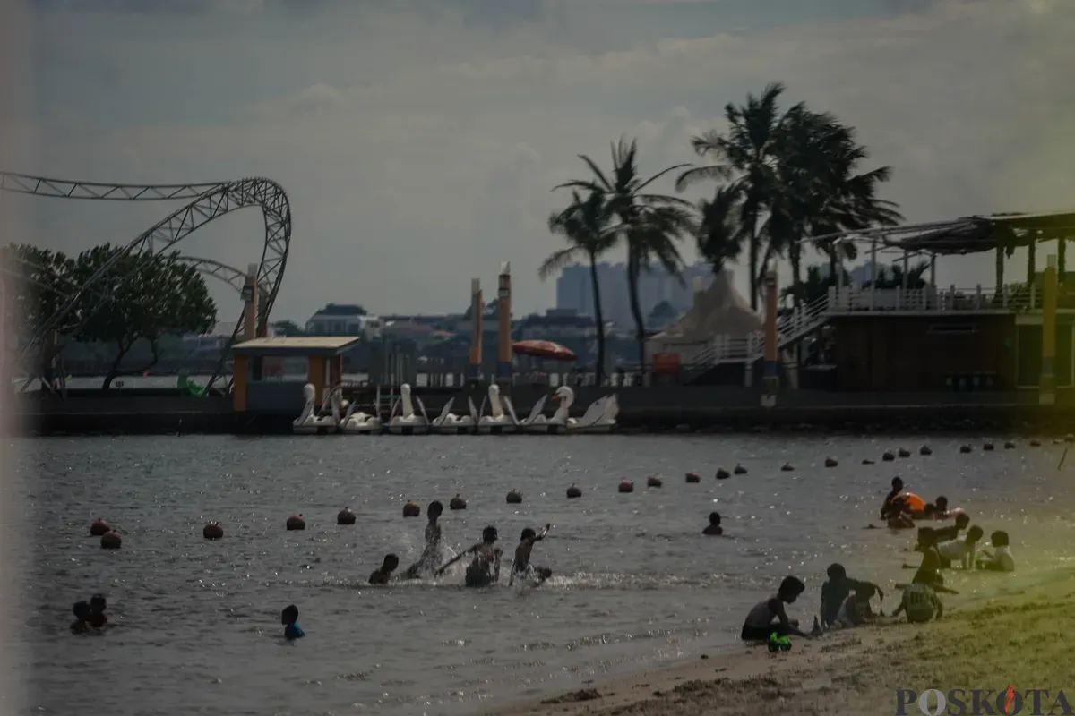 Warga bermain di pesisir Pantai Lagoon, Taman Impian Jaya Ancol, Jakarta, Jumat, 19 Desember 2025. (Sumber: Poskota/Bilal Nugraha Ginanjar)