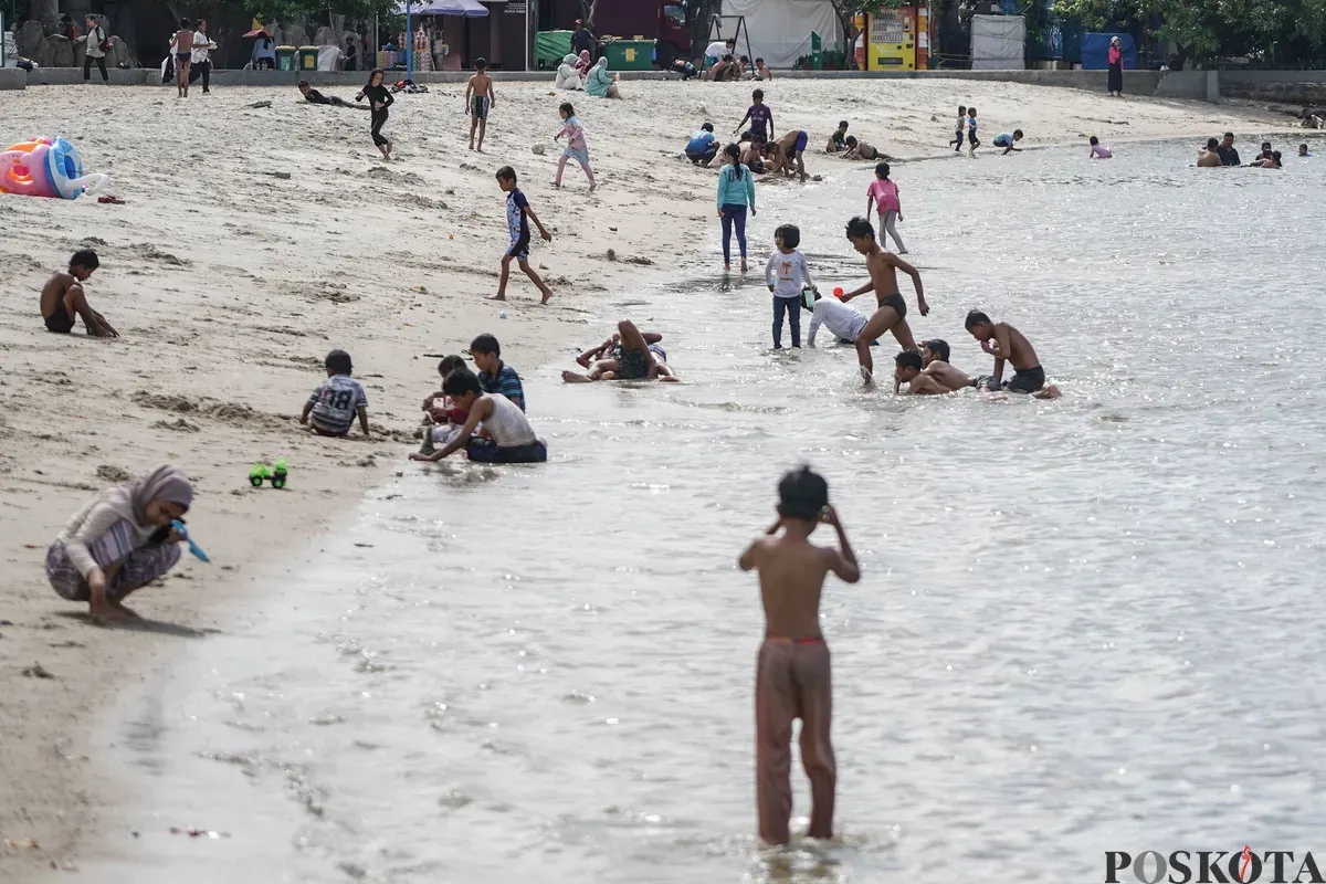 Warga bermain di pesisir Pantai Lagoon, Taman Impian Jaya Ancol, Jakarta, Jumat, 19 Desember 2025. (Sumber: Poskota/Bilal Nugraha Ginanjar)