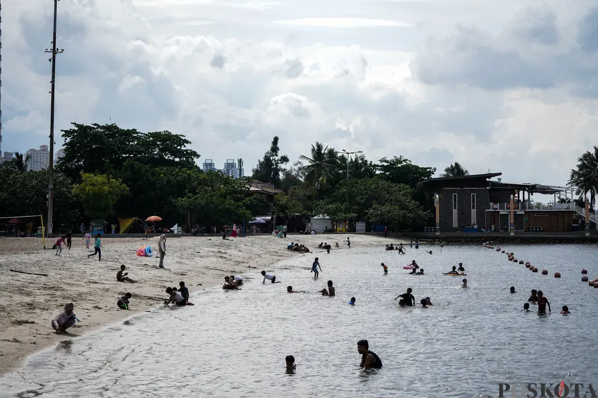 Warga bermain di pesisir Pantai Lagoon, Taman Impian Jaya Ancol, Jakarta, Jumat, 19 Desember 2025. (Sumber: Poskota/Bilal Nugraha Ginanjar)