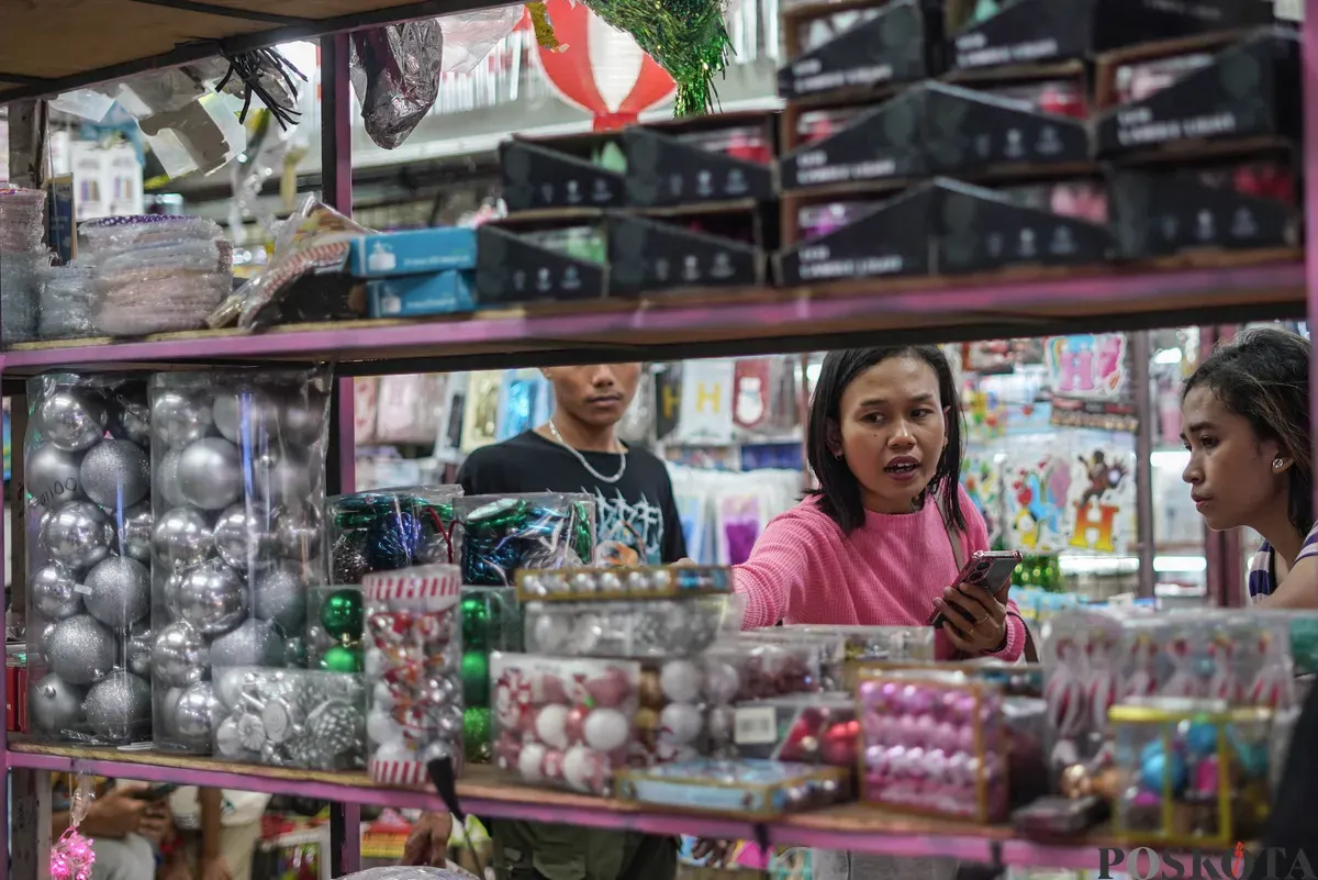 Pengunjung melihat pernak-pernik dekorasi Natal di Pasar Pagi Asemka, Jakarta, Minggu 21 Desember 2025. (Sumber: Poskota/Bilal Nugraha Ginanjar)