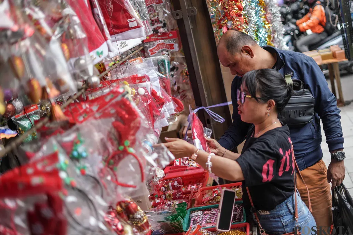 Pengunjung melihat pernak-pernik dekorasi Natal di Pasar Pagi Asemka, Jakarta, Minggu 21 Desember 2025. (Sumber: Poskota/Bilal Nugraha Ginanjar)