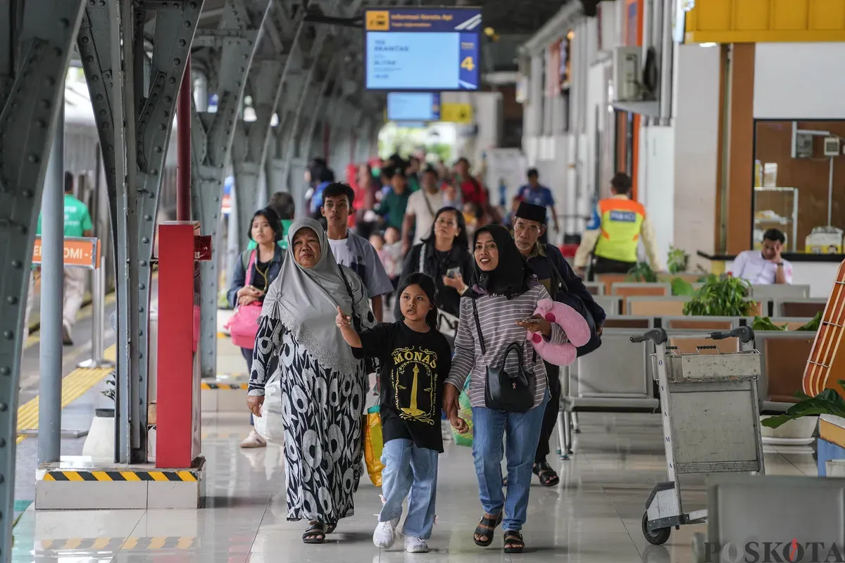 Penumpang berjalan kedalam kereta di Stasiun Pasar Senen, Jakarta Pusat, Minggu, 21 Desember 2025. (Sumber: Poskota/Bilal Nugraha Ginanjar)
