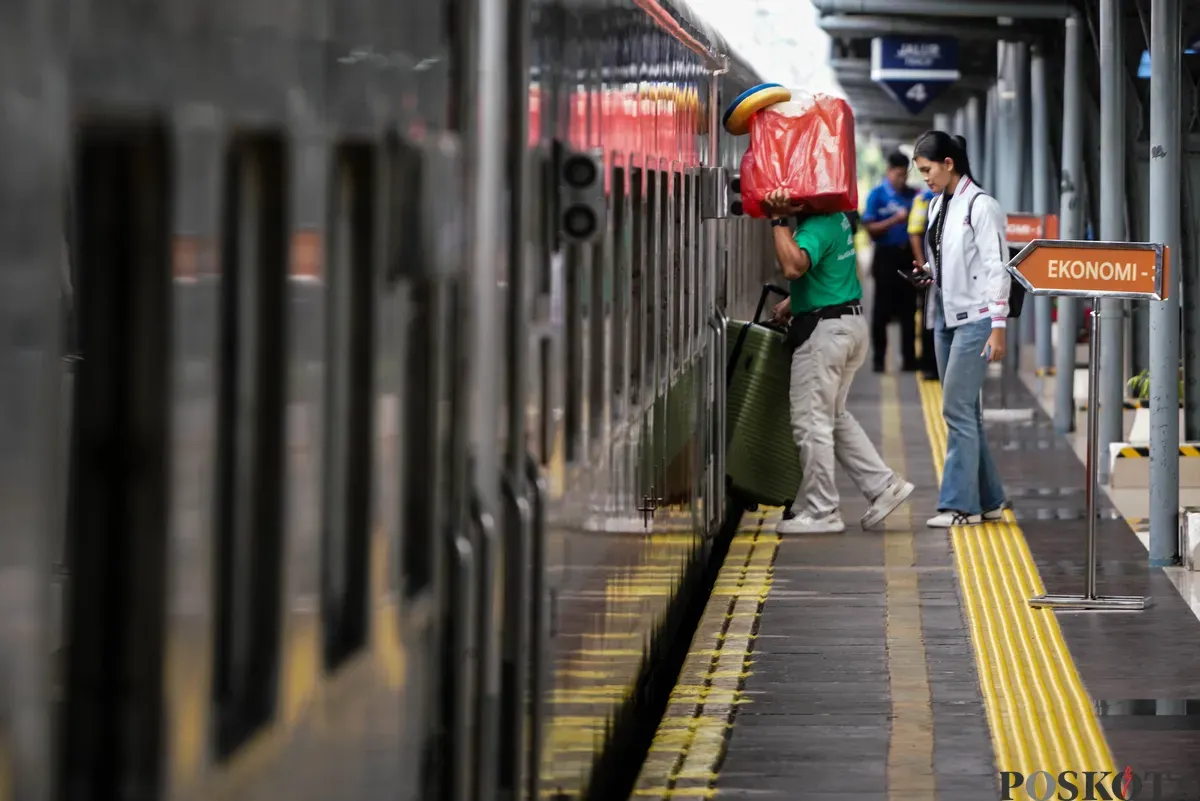Penumpang berjalan kedalam kereta di Stasiun Pasar Senen, Jakarta Pusat, Minggu, 21 Desember 2025. (Sumber: Poskota/Bilal Nugraha Ginanjar)