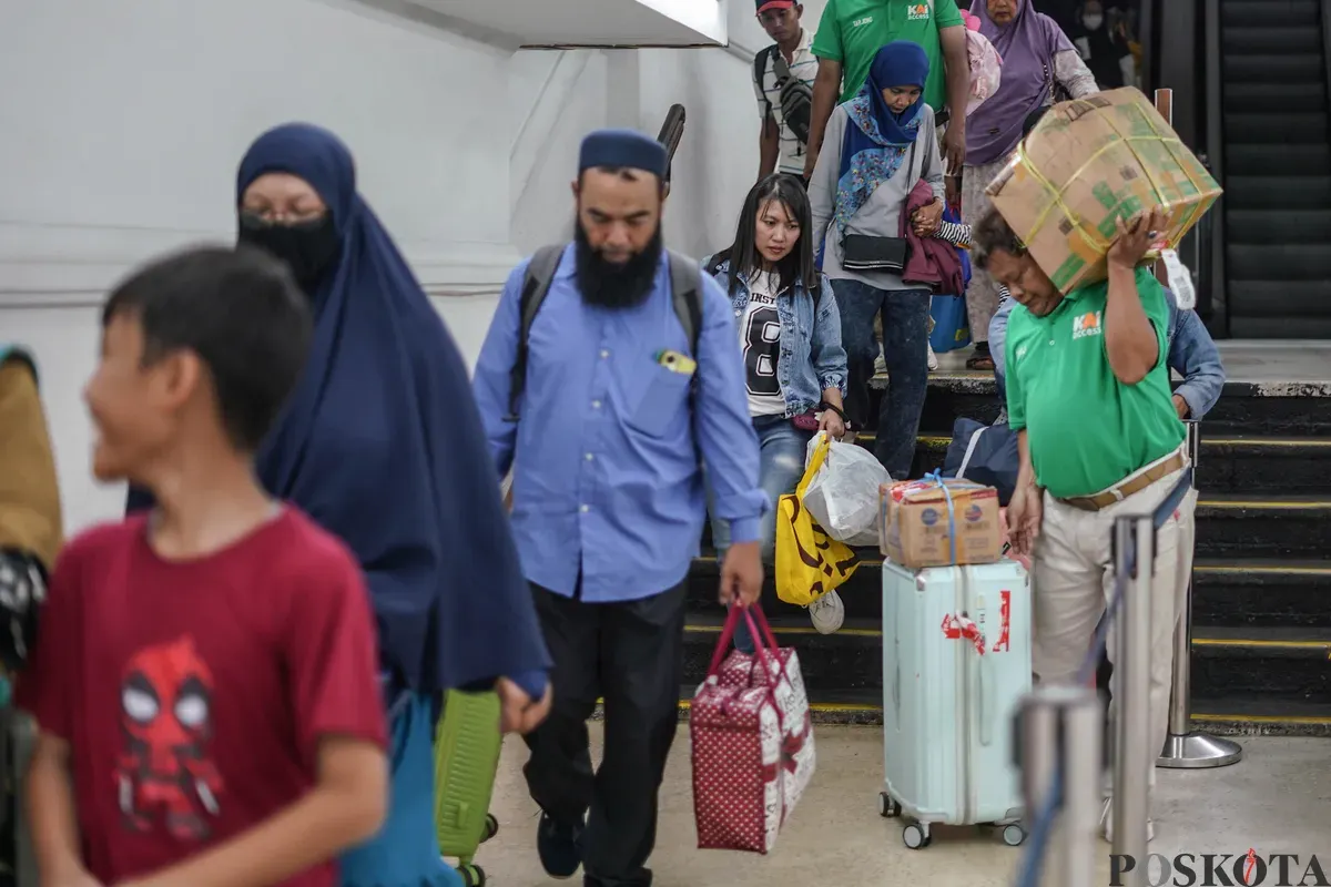 Penumpang berjalan menuju peron kereta di Stasiun Pasar Senen, Jakarta Pusat, Minggu, 21 Desember 2025. (Sumber: Poskota/Bilal Nugraha Ginanjar)