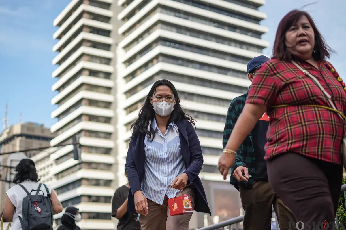 Pekerja berjalan saat jam pulang kerja di Jalan MH Thamrin, Jakarta, Senin, 22 Desember 2025. (Sumber: Poskota/Bilal Nugraha Ginanjar)