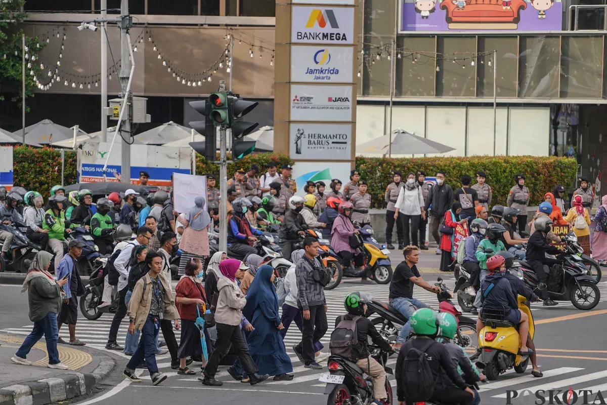 Pekerja berjalan saat jam pulang kerja di Jalan MH Thamrin, Jakarta, Senin, 22 Desember 2025. (Sumber: Poskota/Bilal Nugraha Ginanjar)