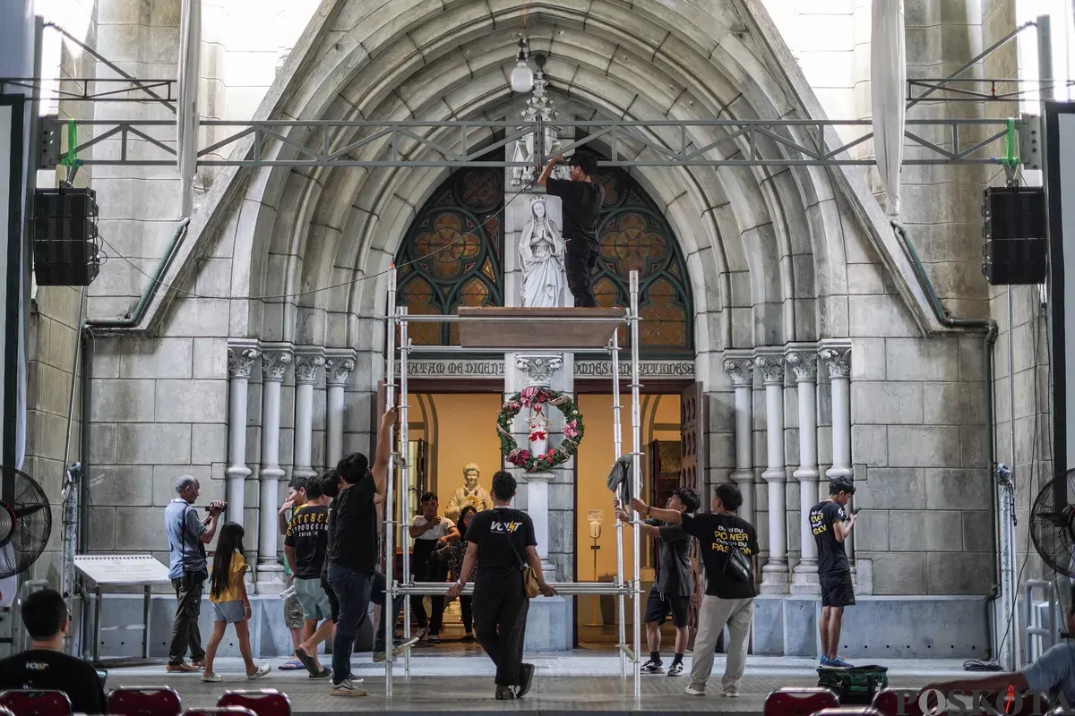 Petugas memasang lampu jelang Natal 2025 di Gereja Katedral, Jakarta, Selasa, 23 Desember 2025. (Sumber: Poskota/Bilal Nugraha Ginanjar)