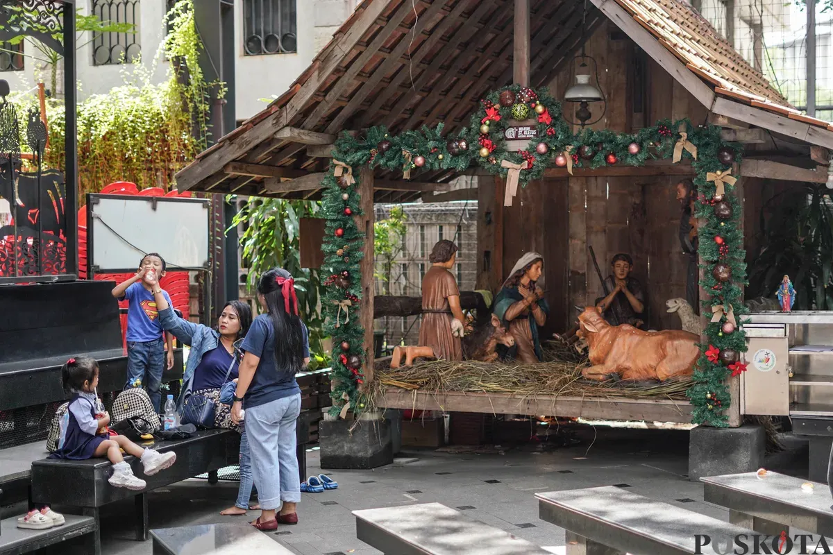 Warga melihat dekorasi jelang Natal 2025 di Gereja Katedral, Jakarta, Selasa, 23 Desember 2025. (Sumber: Poskota/Bilal Nugraha Ginanjar)