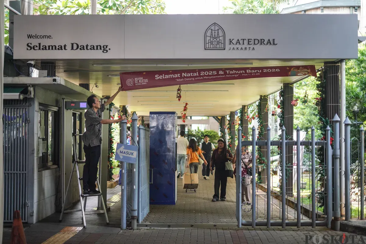Petugas memasang spanduk jelang Natal 2025 di Gereja Katedral, Jakarta, Selasa, 23 Desember 2025. (Sumber: Poskota/Bilal Nugraha Ginanjar)