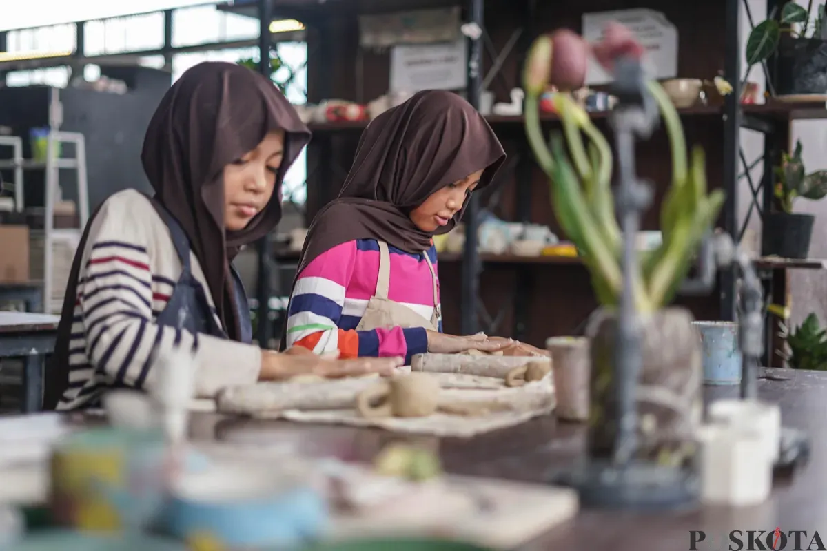 Pengunjung membuat kerajinan keramik dengan teknik tangan bebas dalam kelas pembuatan kerajinan tanah liat di Lost in Clay Pottery Studio, Taman Ismail Marzuki, Jakarta, Minggu, 28 Desember 2025. (Sumber: Poskota/Bilal Nugraha Ginanjar)