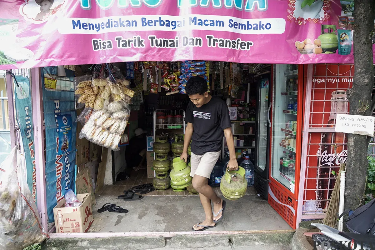 Warga membawa dua tabung gas elpiji 3 Kg yang dibelinya dari warung kelontong di kawasan Palmerah, Jakarta Barat, Sabtu, 1 Februari 2025. (Sumber: Poskota/Bilal Nugraha Ginanjar)