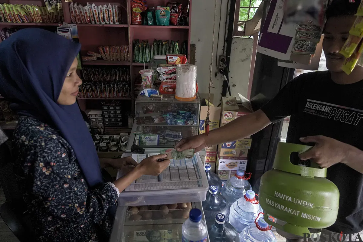 Warga membawa dua tabung gas elpiji 3 Kg yang dibelinya dari warung kelontong di kawasan Palmerah, Jakarta Barat, Sabtu, 1 Februari 2025. (Sumber: Poskota/Bilal Nugraha Ginanjar)