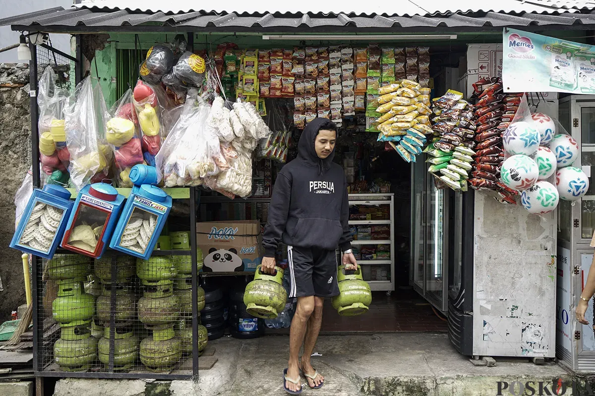 Warga membawa dua tabung gas elpiji 3 Kg yang dibelinya dari warung kelontong di kawasan Palmerah, Jakarta Barat, Sabtu, 1 Februari 2025. (Sumber: Poskota/Bilal Nugraha Ginanjar)