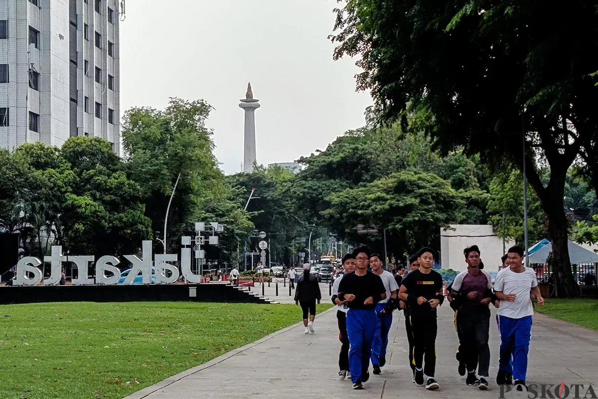 Sejumlah warga mengsi aktivitasnya sambil menikmati suasana Ruang Terbuka Hijau (RTH) di Taman Lapangan Banteng, Jakarta, Senin, 3 Februari 2025. (Sumber: Poskota/Bilal Nugraha Ginanjar)