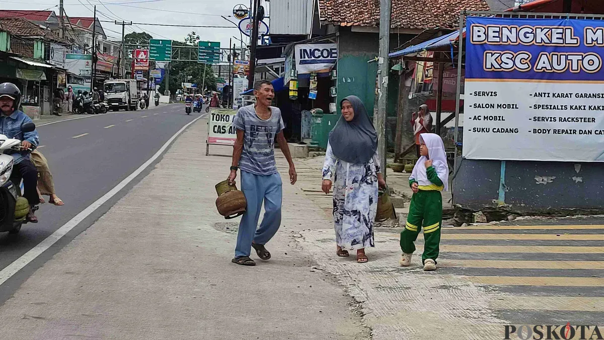 Warga Kampung Cipacung, Kelurahan Saruni, Kecamatan Majasari, Pandeglang, menenteng tabung gas LPG 3 kg. (Sumber: Poskota/Samsul Fatoni)