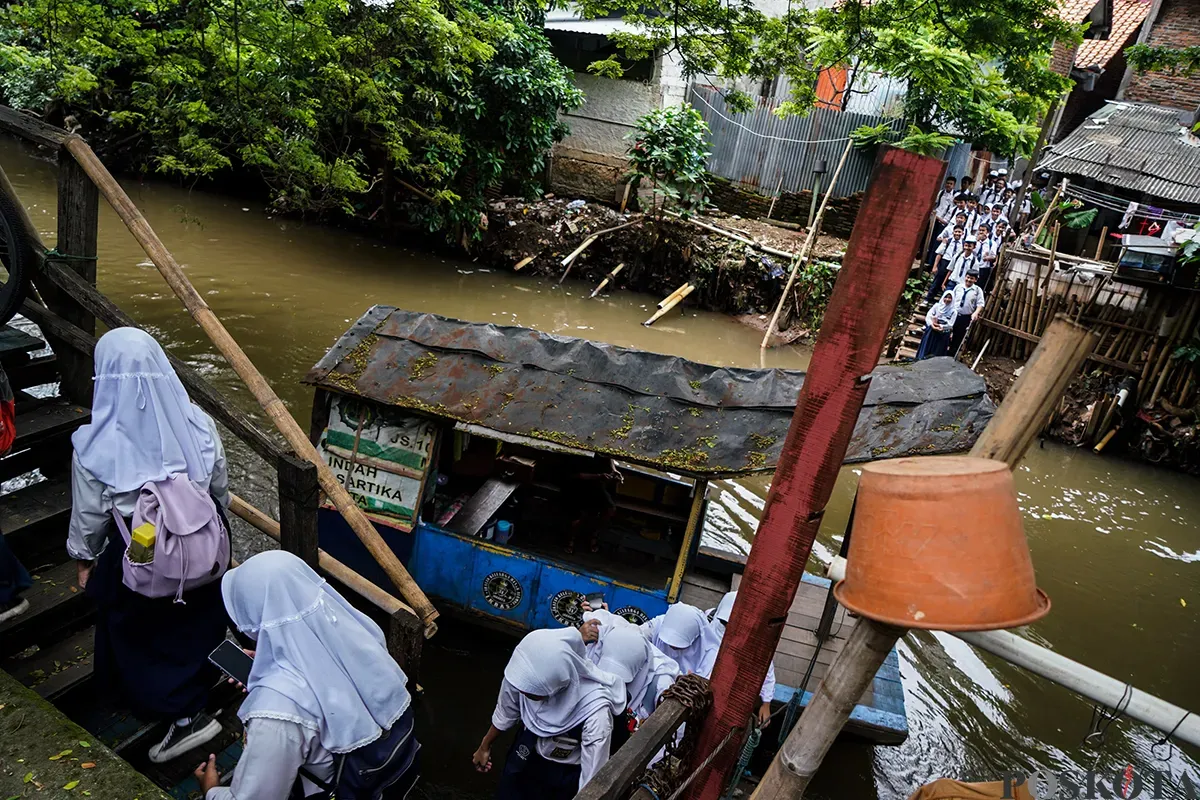 Sejumlah pelajar sekolah menengah ketika sebelum dan sesudah menaiki perahu eretan usai jam pulang sekolah untuk menyeberangi Kali Pesanggrahan, Jakarta Selatan, Selasa, 4 Februari 2025. (Sumber: Poskota/Bilal Nugraha Ginanjar)