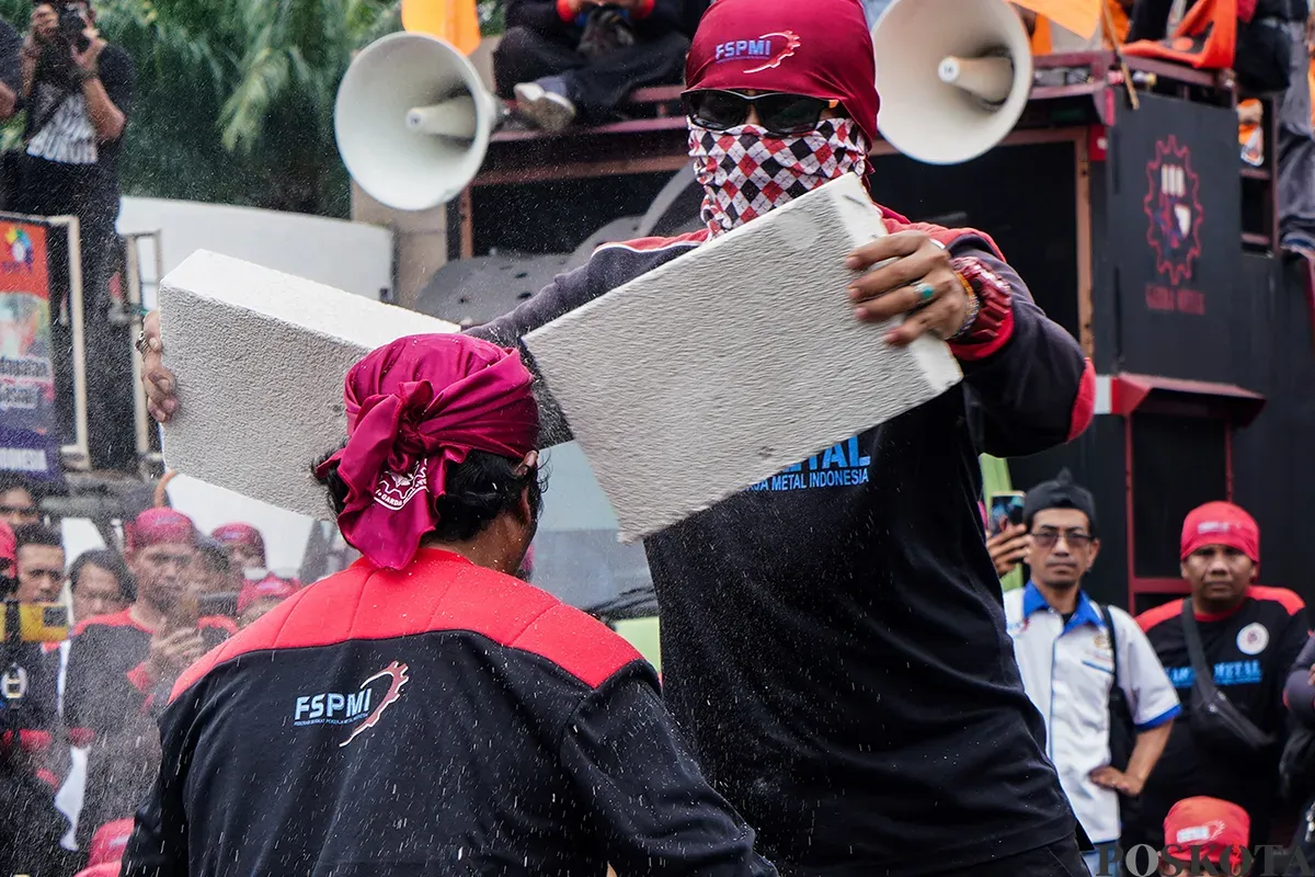 Ratusan buruh yang tergabung dari berbagai serikat pekerja melakukan kasi damai dengan menampilkan teatrikal pencak silat di depan kompleks Parlemen, Senayan, Jakarta, Kamis, 6 Februari 2025. (Sumber: Poskota/Bilal Nugraha Ginanjar)